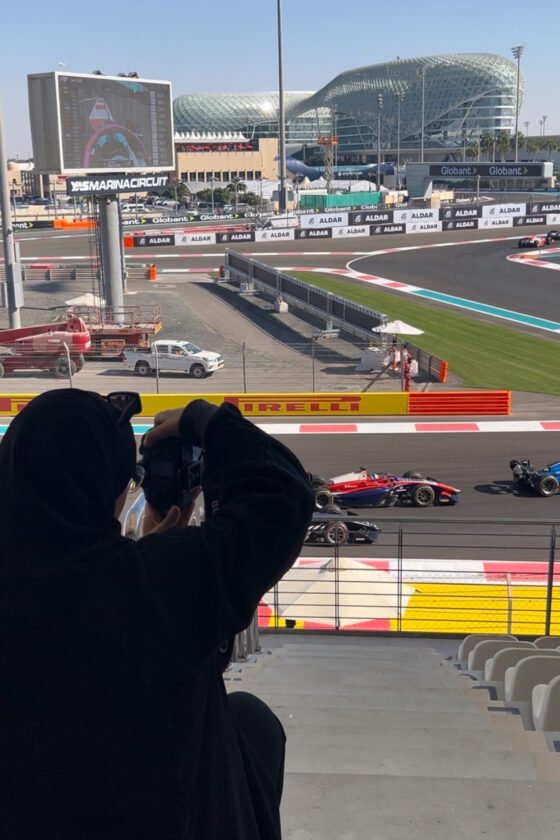 Spectator photographing Formula 1 cars at Yas Marina Circuit in Abu Dhabi