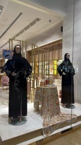 Mannequins showcasing embroidered abayas inside Mauzan boutique in Abu Dhabi, highlighting modest fashion and premium abaya fabrics.