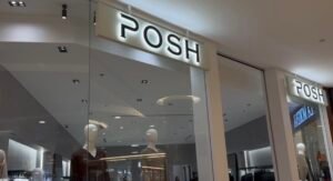 Front view of Posh Abaya store in Abu Dhabi mall featuring minimalist mannequins and bright signage.