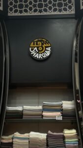 Stacked scarves in pastel shades displayed inside Sharqiaa Abaya store in Abu Dhabi.