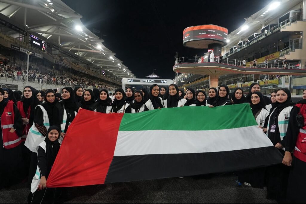 Emirati women holding the UAE flag at Yas Marina Circuit during Abu Dhabi Grand Prix