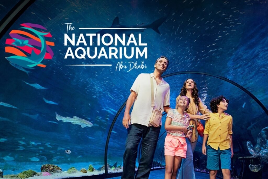 A family exploring the National Aquarium Abu Dhabi surrounded by marine life.
